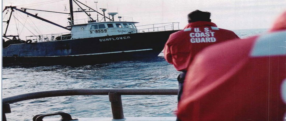 A Coast Guard vessel prepares to board a fishing boat to inspect its compliance with fisheries regulations.